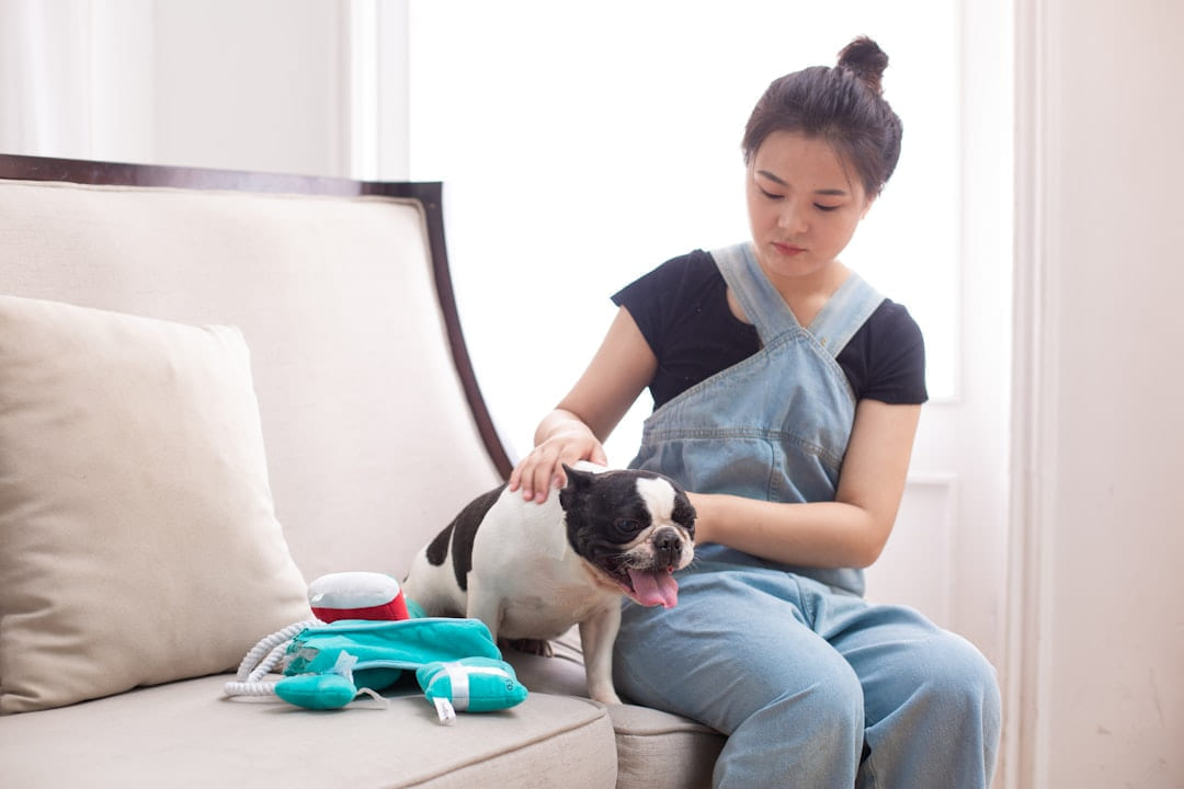 A woman pets her dog on a couch. on Happy Paws Daily
